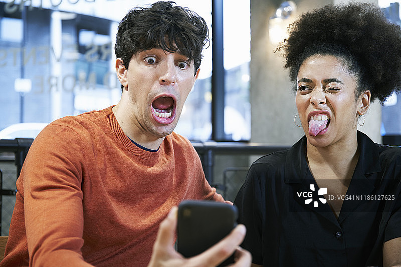 两个年轻人做着鬼脸自拍图片素材