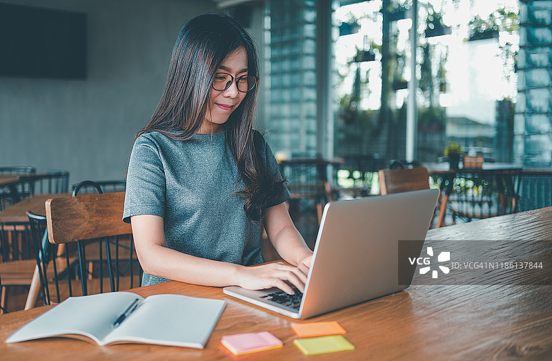 大学教育知识概念：商务女性在咖啡馆使用笔记本电脑图片素材