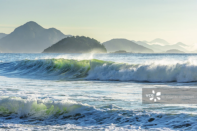 日落时海浪拍打山脉风光图片素材