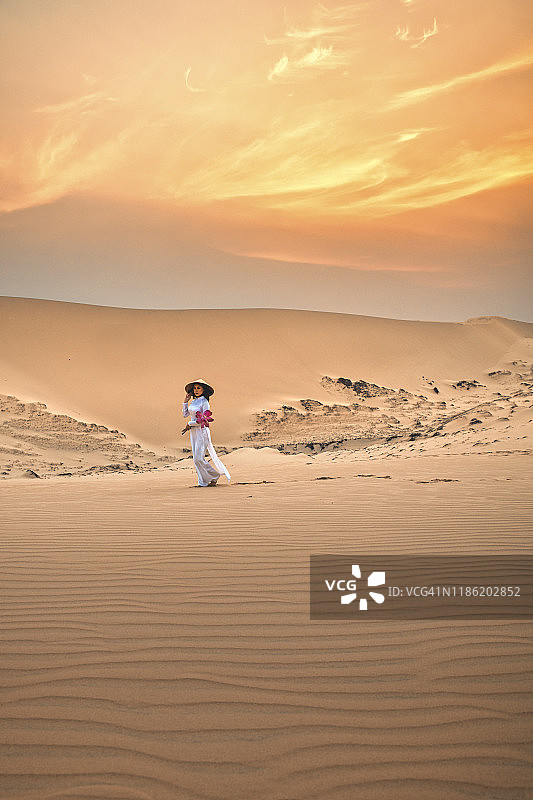 越南美奈沙漠沙丘中手捧莲花的越南女性图片素材