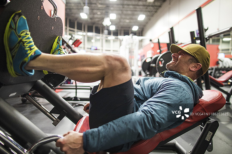 男人在健身房做腿部训练图片素材