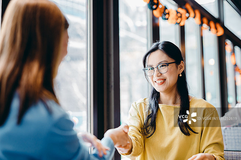 两位亚洲女商人会面并握手图片素材