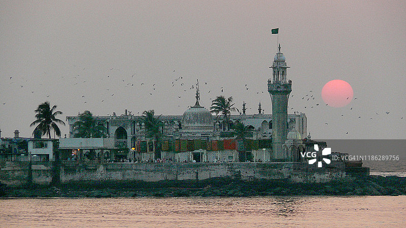 印度马哈拉施特拉邦孟买哈吉·阿里清真寺的日落和鸟群图片素材