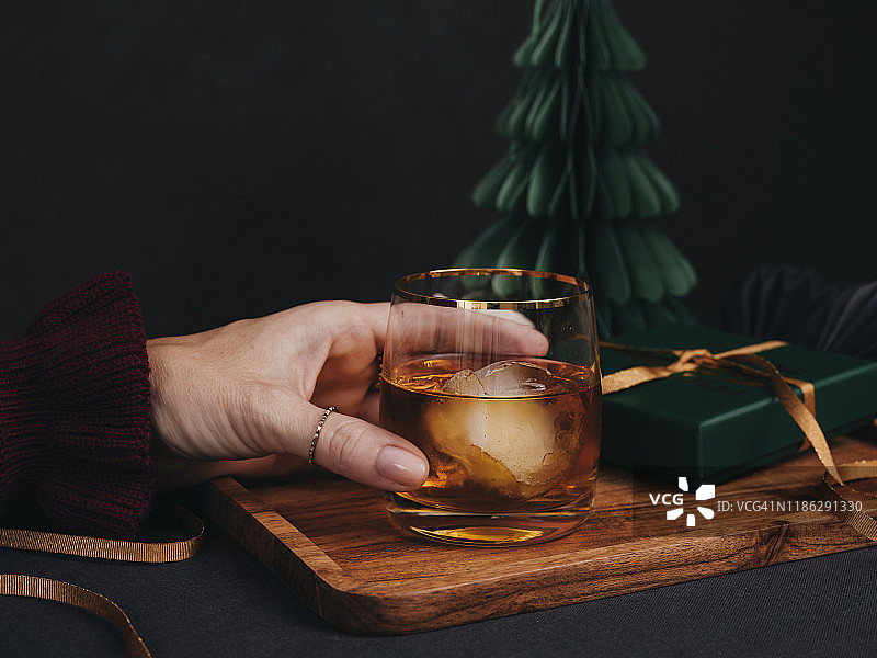 圣诞氛围中喝白兰地、威士忌或冰镇朗姆酒的女人图片素材