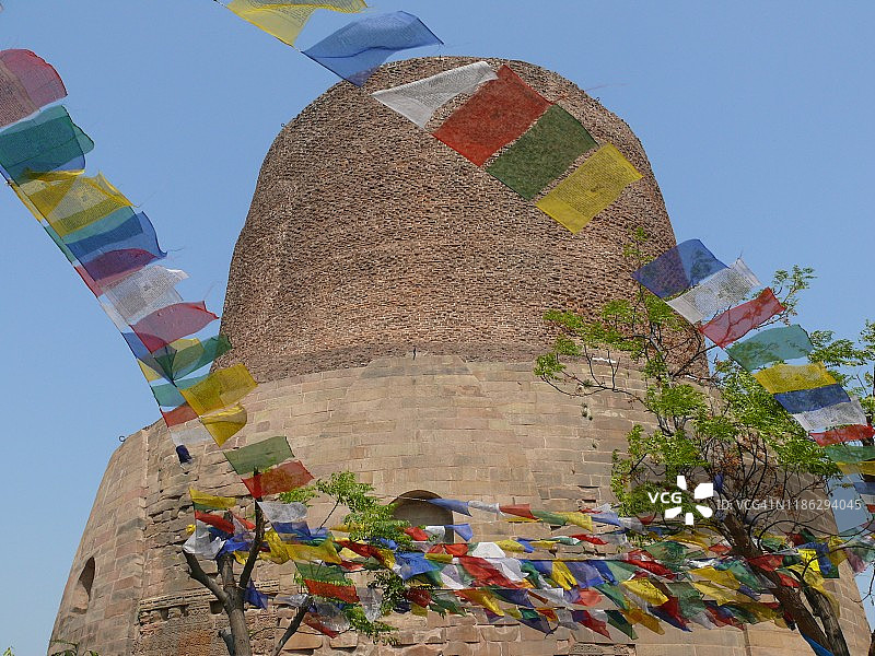 印度北方邦萨尔纳特的达美克佛塔和彩色佛教祈祷旗图片素材