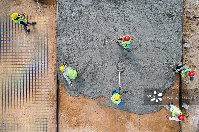 建筑工人在道路施工现场浇筑湿混凝土图片素材