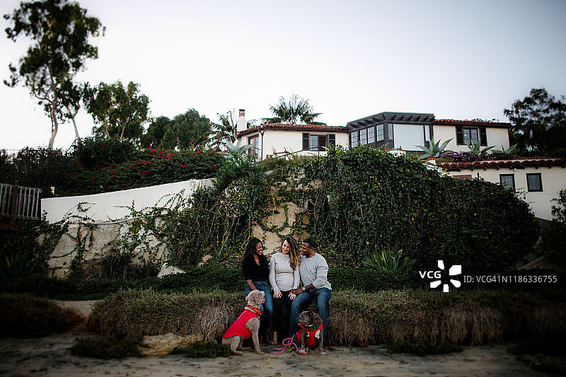 日落时分，海滩上的一家人和狗图片素材