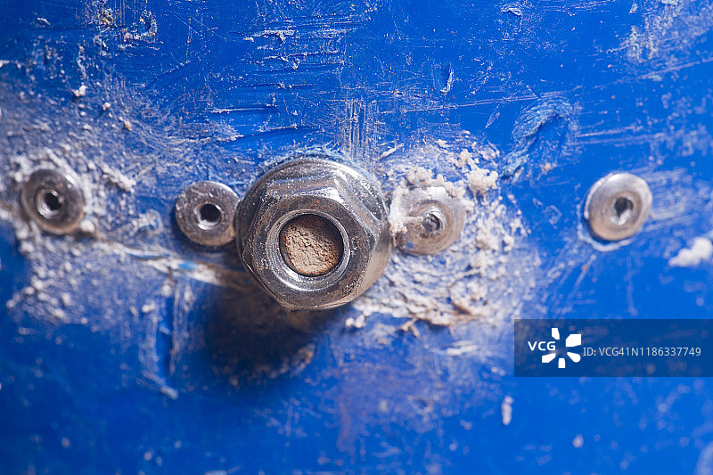 螺母和螺栓，蓝色塑料管连接到木制支架上图片素材