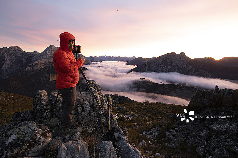 男人在山顶拍摄日出时的薄雾图片素材