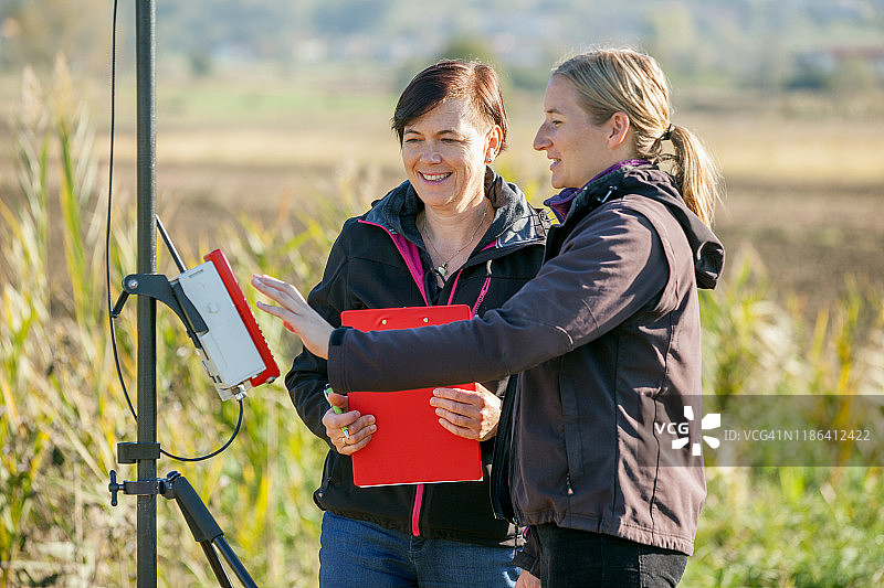 女测量员在乡村场景中使用GPS工作工具图片素材