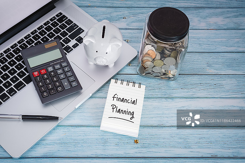 笔记本电脑上的财务规划（木质背景）图片素材