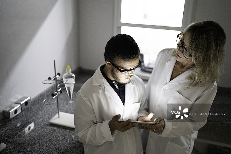 中年妇女和有特殊需求的男子在实验室里一起工作图片素材