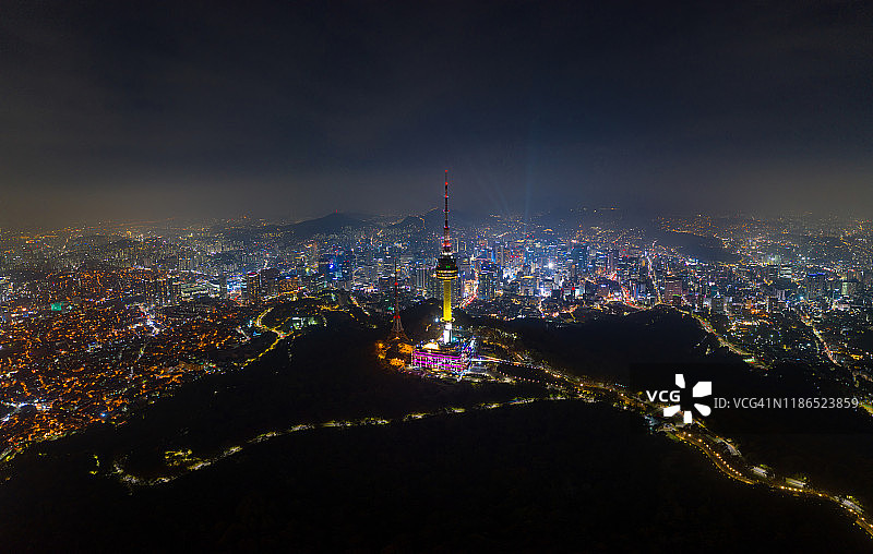 韩国首尔南山N首尔塔全景鸟瞰图，首尔市中心城市天际线和道路上的车辆光迹图片素材