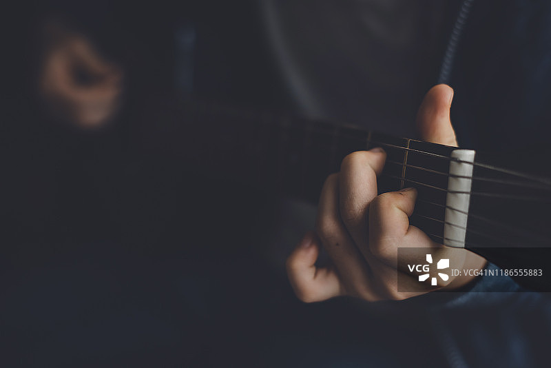 男孩在家弹吉他的中部照片图片素材