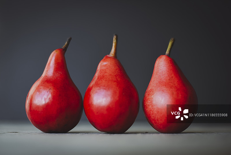 桌子上并排摆放的红色梨子特写图片素材
