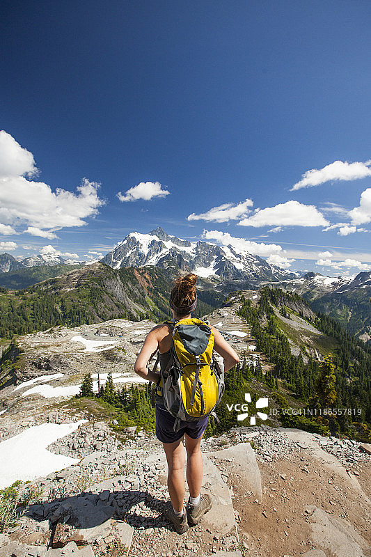 晴朗蓝天下，徒步者观山的背影图片素材