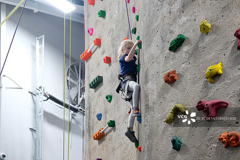 在室内攀岩馆攀岩的年轻女孩图片素材
