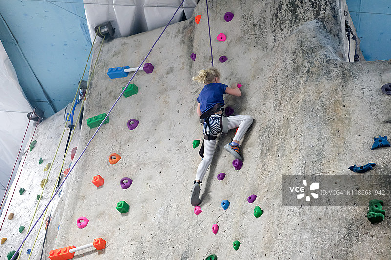 在室内攀岩馆攀岩的年轻女孩图片素材