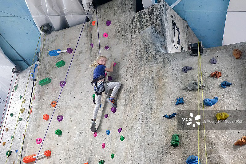 在室内攀岩馆攀岩的年轻女孩图片素材