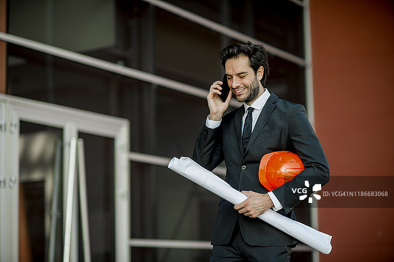 工程师在用手机交谈，面带微笑图片素材