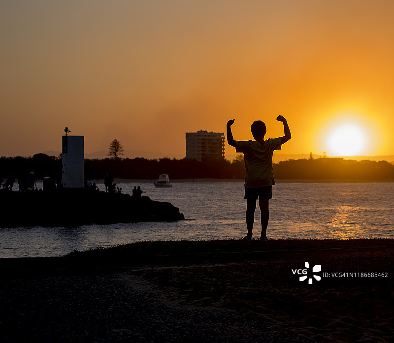 日落时分水边男孩剪影图片素材