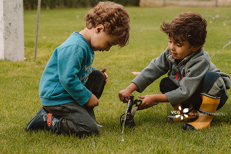 男孩们玩洒水器图片素材
