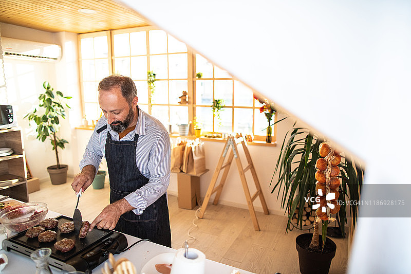 男人在家中现代厨房制作自制汉堡图片素材