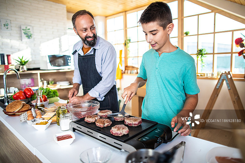 少年在厨房里烤汉堡图片素材