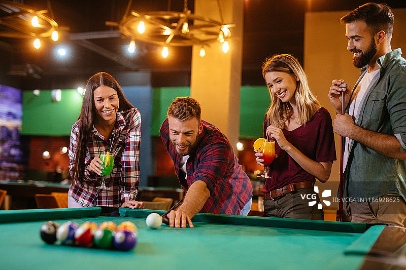 朋友们在当地的台球厅里玩台球图片素材