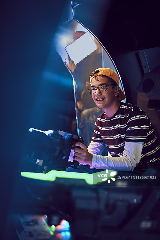 青少年男孩在游乐厅玩驾驶模拟器图片素材