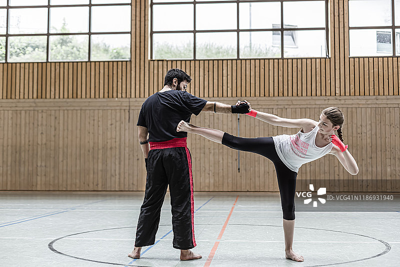 体育馆内女拳击手与教练对练图片素材