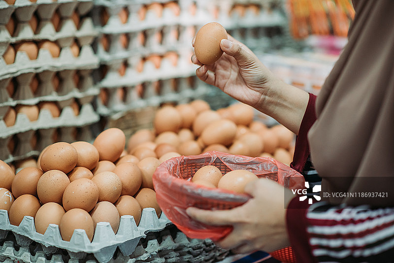 马来西亚籍亚洲女性在早市挑选优质鸡蛋图片素材