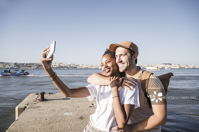 幸福的年轻夫妇在葡萄牙里斯本码头自拍图片素材