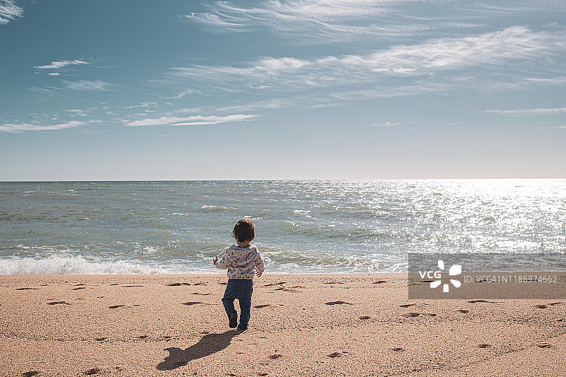 小男孩在海滩上散步图片素材