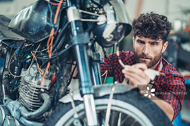 年轻男人制造摩托车图片素材