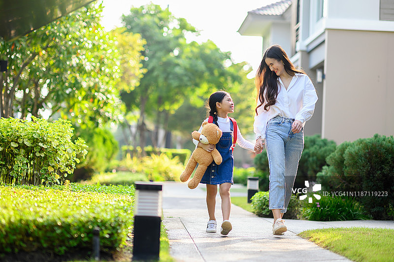 母亲和女儿一起散步，学校概念图片素材