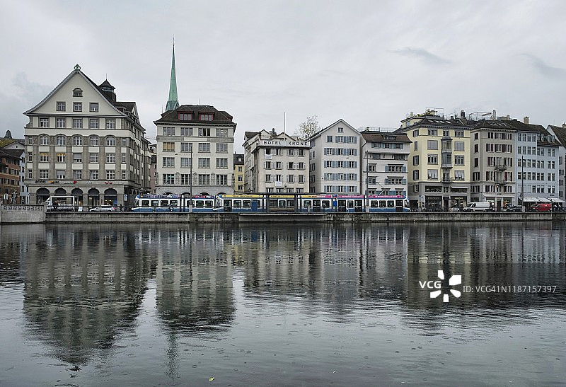 苏黎世利马特河左侧的建筑物、有轨电车和倒影图片素材
