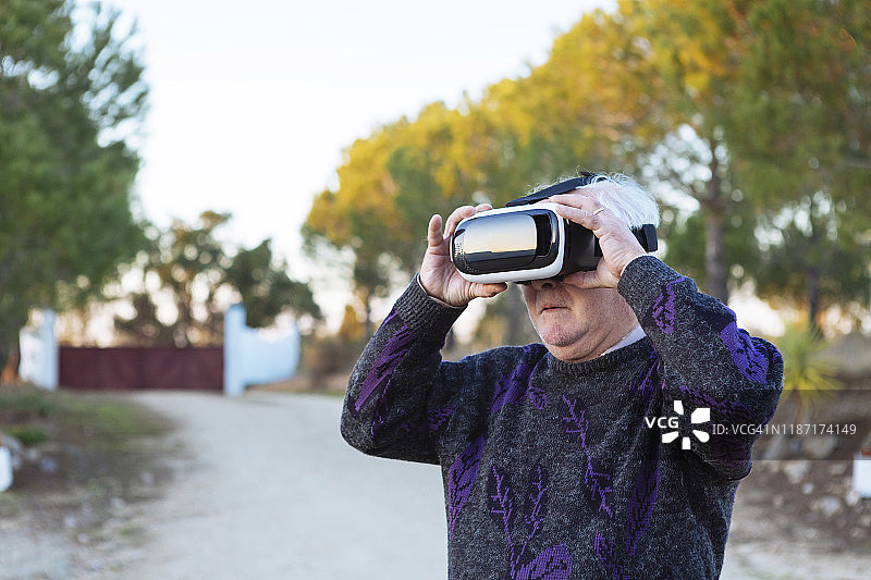 在户外佩戴VR模拟器的年长男人图片素材