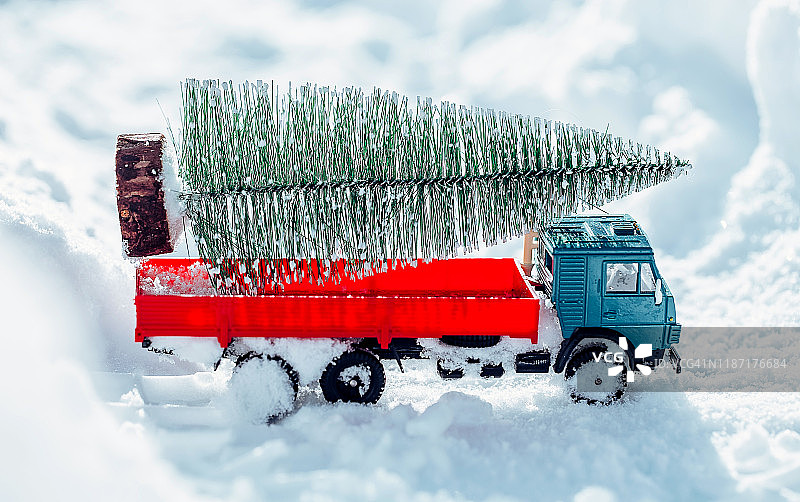 雪堆背景上的圣诞树玩具卡车图片素材