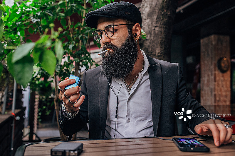 吸烟听音乐的时尚男人图片素材