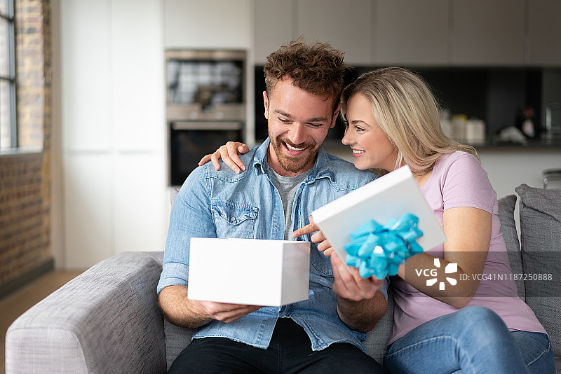 快乐的男子打开他的生日礼物图片素材