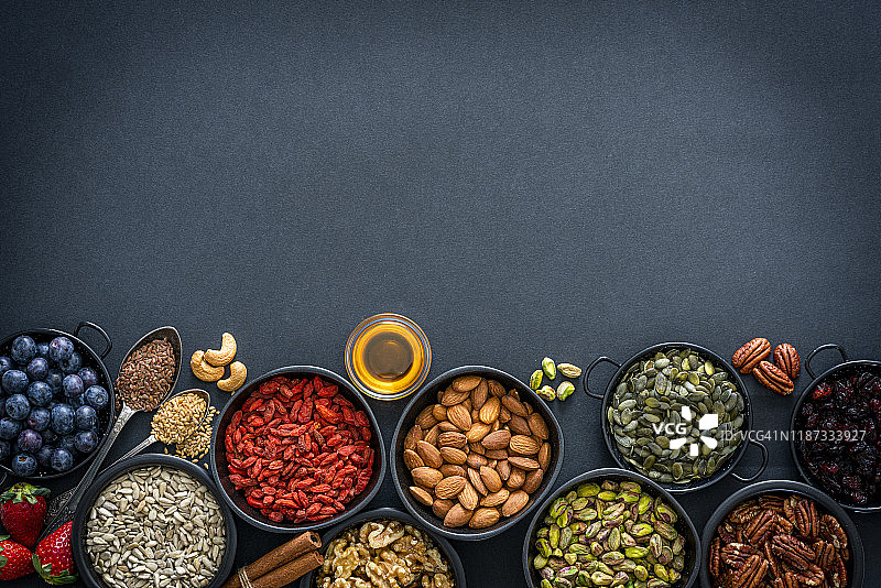 健康饮食背景：坚果、种子和水果拼盘边框（俯视图）图片素材