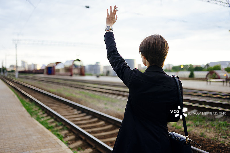 挥手告别火车的女人图片素材