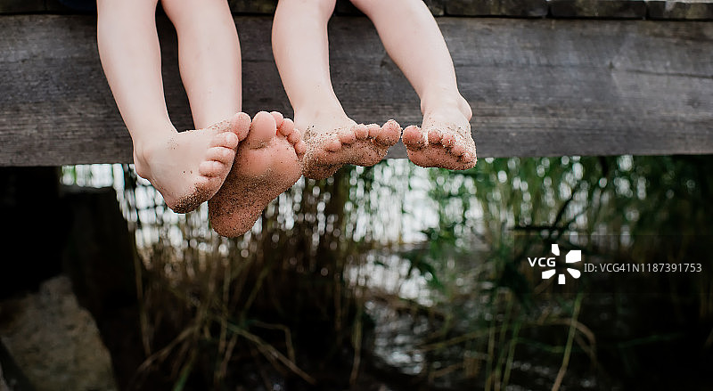 沙滩码头上晃荡的两双小脚图片素材