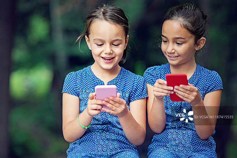 两个姐妹在玩手机图片素材