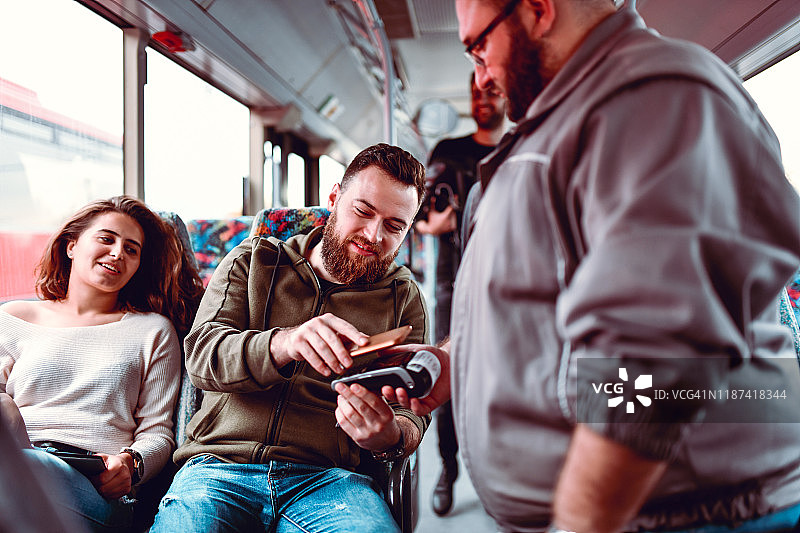 用智能手机支付公交车票的男人图片素材