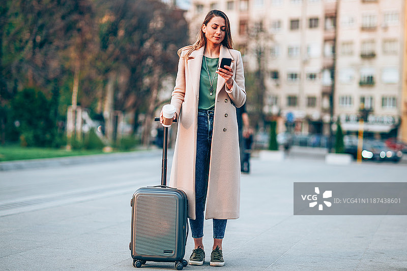 年轻游客在智能手机上看城市地图图片素材