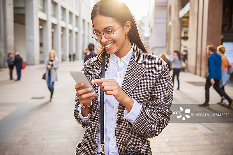 在户外发短信的时尚女人图片素材