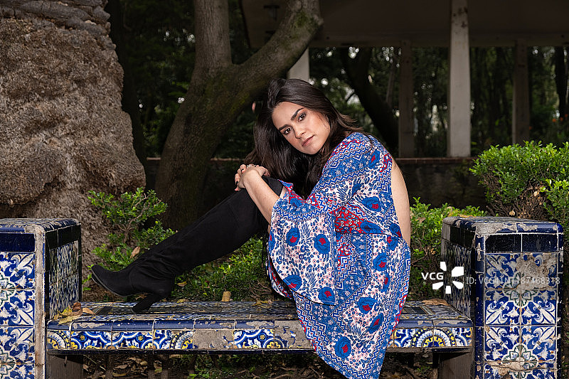 墨西哥城瓷砖长椅上的年轻西班牙裔女子图片素材