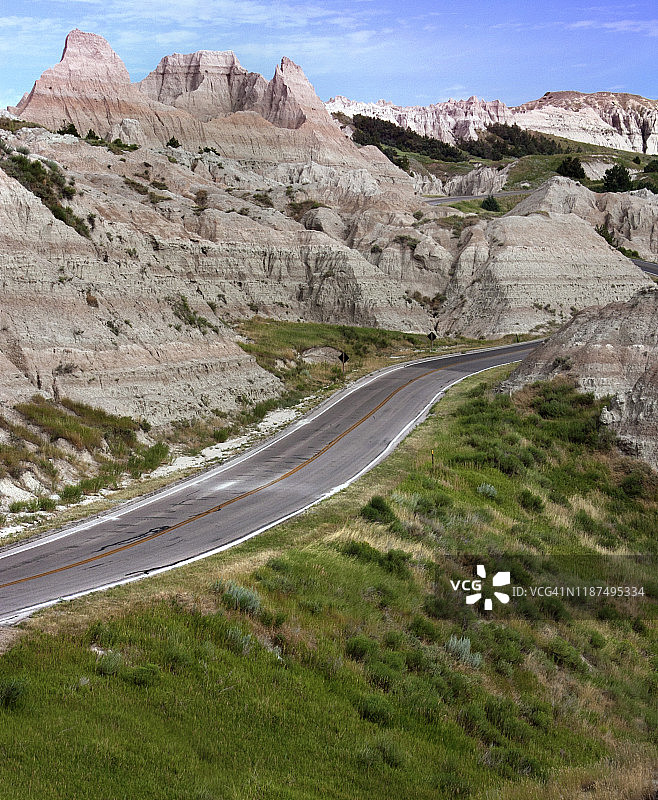 阳光明媚的恶地国家公园的蜿蜒道路图片素材